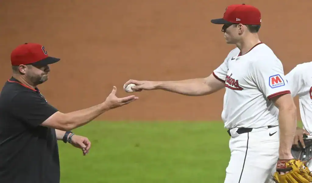 Cleveland Guardians pitcher hands ball to manager during game vs Rockies on July 29 2025