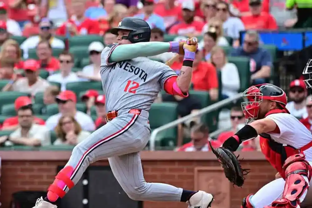 Minnesota Twins vs Tampa Bay Rays Picks and Predictions July 6th 2025 2 A baseball player is seen swinging a bat in an outdoor baseball park. He is wearing a sports uniform and surrounded by the excitement of a live game