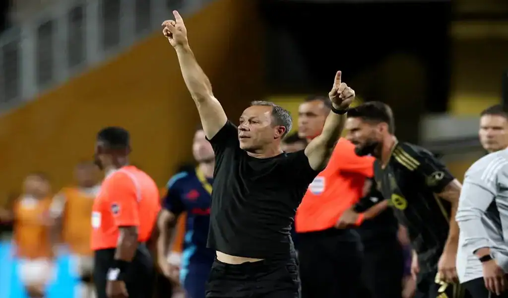 LAFC coach raising both arms to celebrate during the match against FC Dallas