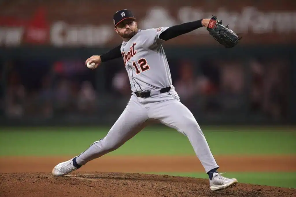 A pitcher in a gray Detroit Tigers uniform winds up to throw a baseball on the field, showcasing athleticism and focus.