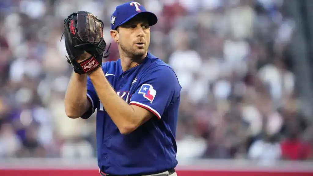 Toronto Blue Jays vs New York Yankees Picks and Predictions July 1st 2025 2 A pitcher in a blue Texas Rangers jersey grips a baseball glove, preparing to throw amidst a cheering crowd in the background.