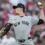 The athlete is dressed in a traditional baseball uniform and is engaged in the sport of college baseball, where he positions himself to pitch.