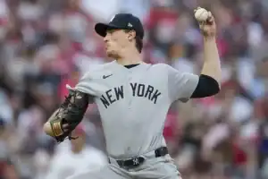 The athlete is dressed in a traditional baseball uniform and is engaged in the sport of college baseball, where he positions himself to pitch.