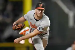 Dressed in a baseball uniform and equipped with typical baseball gear, the player showcases athleticism in this outdoor sports setting.
