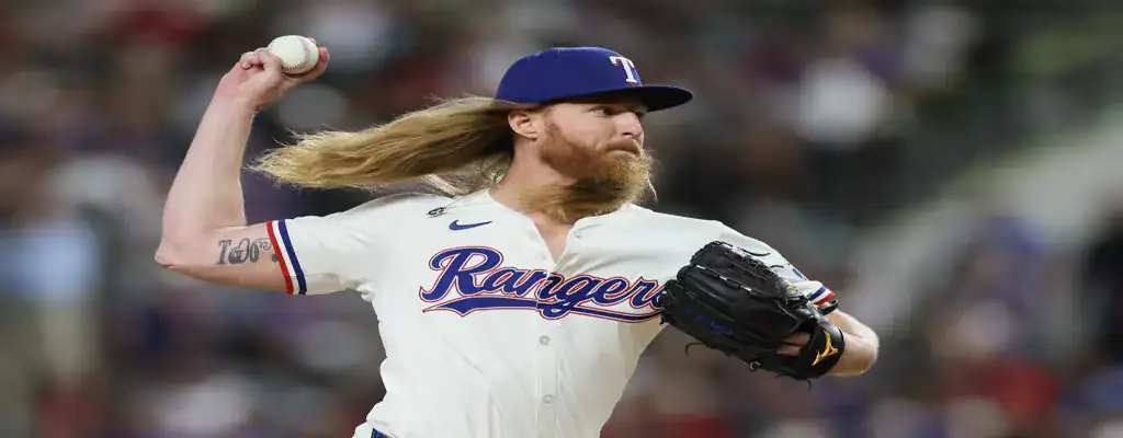 Texas Rangers pitcher with long hair delivering a pitch during an MLB game