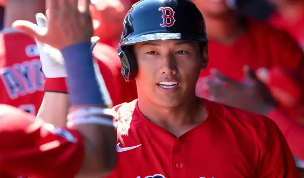 Boston Red Sox player celebrating with teammates during game against the Colorado Rockies