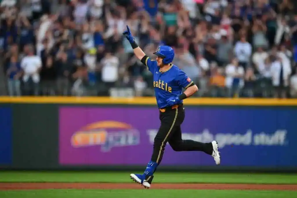 2 A Seattle Mariners player in a royal blue and yellow City Connect jersey celebrates as he runs the bases.