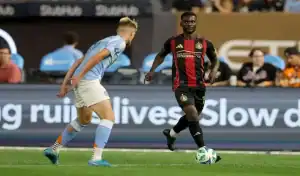 Atlanta United player dribbling the ball while facing a Toronto FC defender during an MLS match