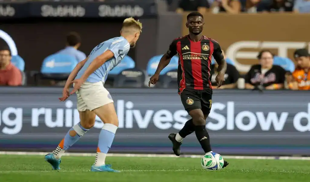 Atlanta United player dribbling the ball while facing a Toronto FC defender during an MLS match