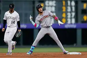 An Arizona Diamondbacks player gestures toward the dugout while standing on second base, with a Colorado Rockies player nearby.