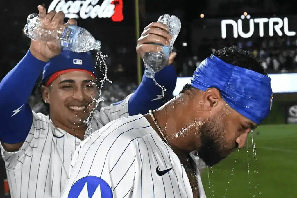 Cubs players pour water on teammate after game.