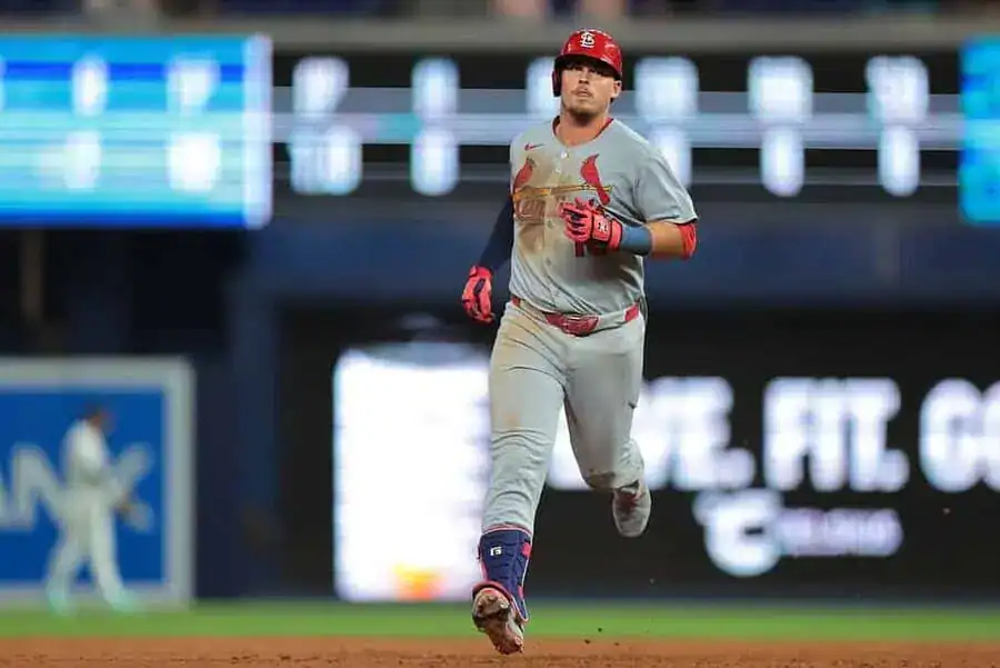 St. Louis Cardinals player runs the bases in a gray road uniform.