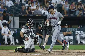 Cleveland Indians player runs past White Sox catcher at home plate.