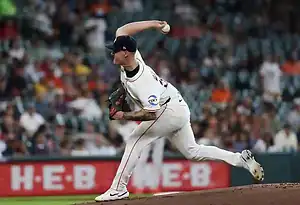 Detroit Tigers pitcher in white uniform throws a pitch during a game.