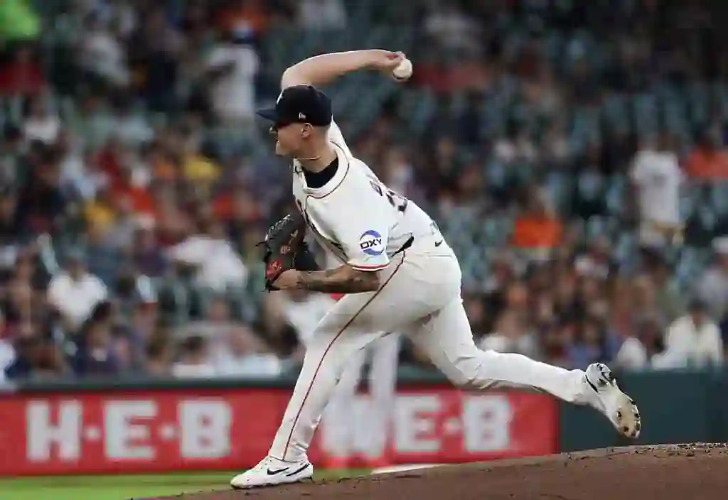 Detroit Tigers pitcher in white uniform throws a pitch during a game.