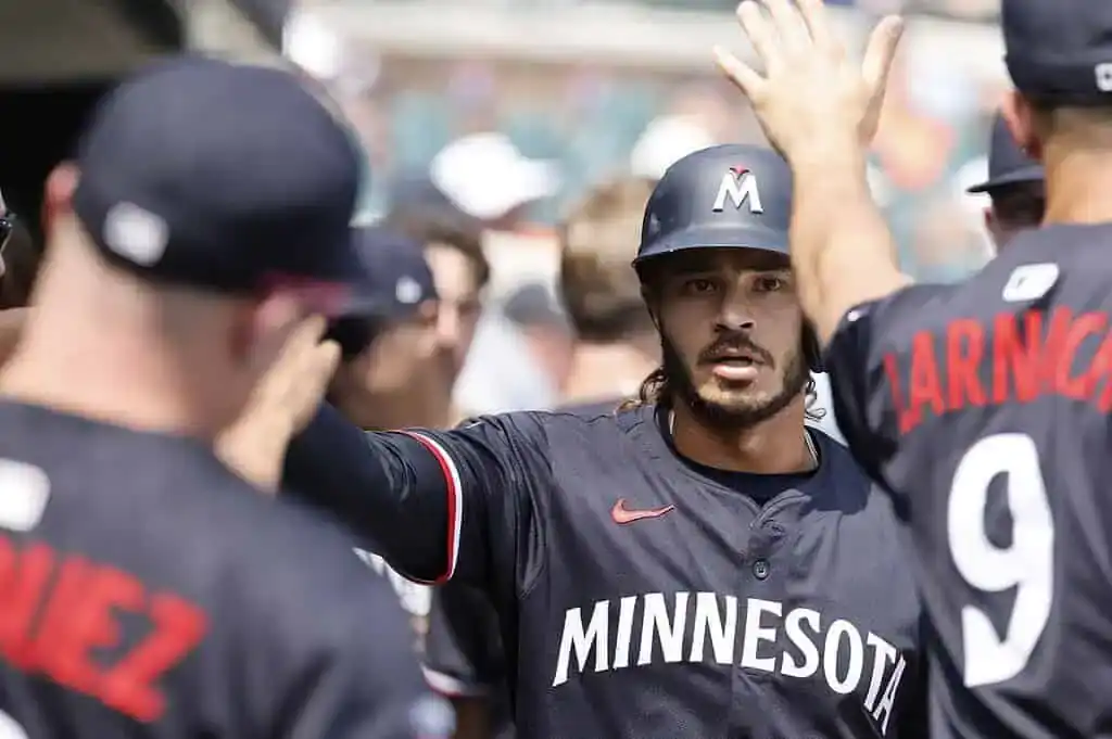 A group of baseball players in black jerseys celebrate together, showcasing team spirit and excitement during a game.
