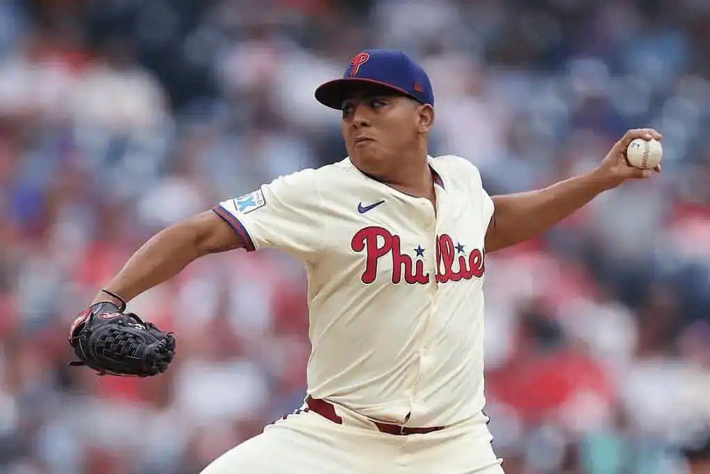 Philadelphia Phillies pitcher delivering a pitch in full motion during a game.