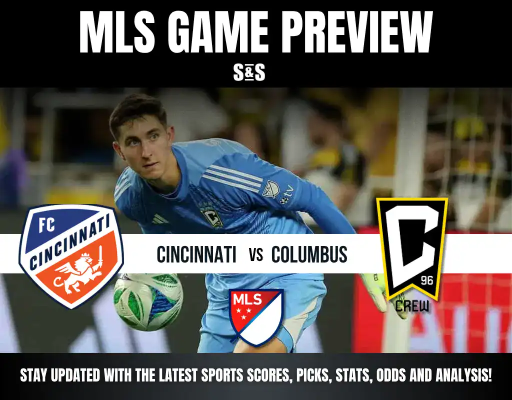 A goalkeeper in a blue uniform prepares to make a save, with team logos for FC Cincinnati and Columbus Crew prominently displayed.