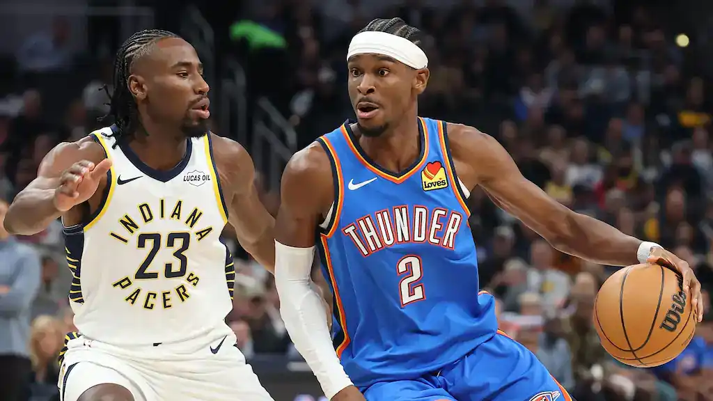 Indiana Pacers player wearing jersey number 23 defends against Oklahoma City Thunder's number 2, who is dribbling the basketball while driving toward the basket during an NBA game.